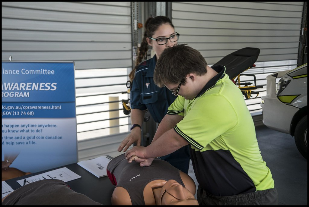 Man in yellow shirt demonstrating CPR