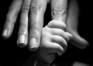 infant's hand grasping an adult finger