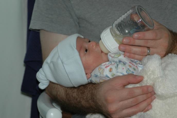 A father bottle-feeding his infant.